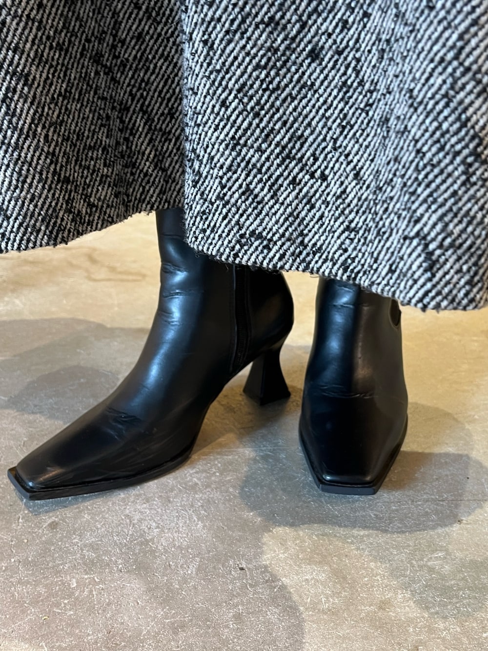 ベージュ系のシャツ/ブラウス、ブラック系のスカート、ブラック系のブーツを着用したレディースの冬コーディネートの9枚目の写真