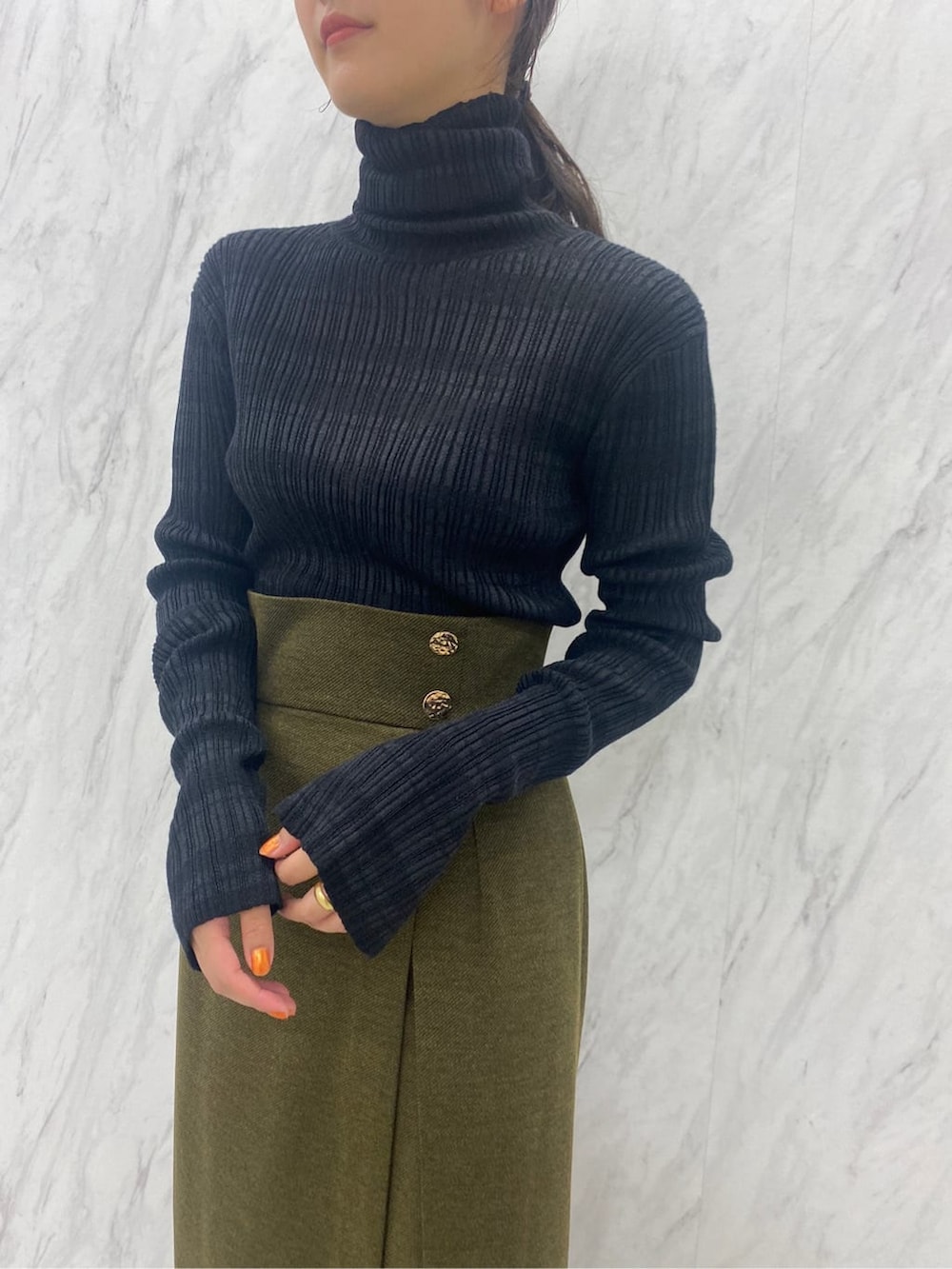 ベージュ系のスカート、ブラック系のニット/セーター、ブラック系のブーツを着用したレディースの夏コーディネートの8枚目の写真