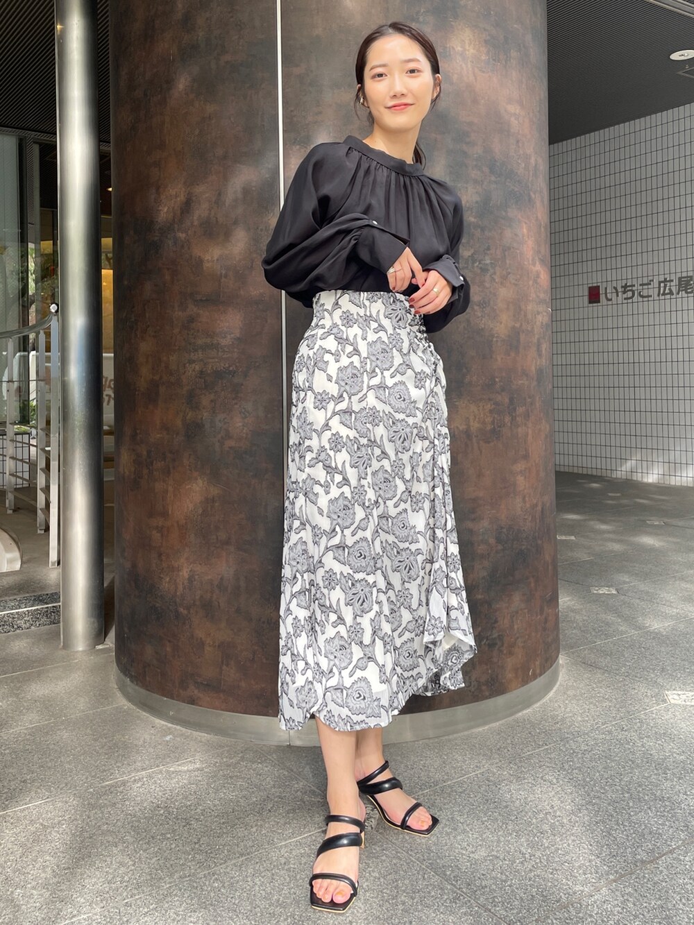 ベージュ系のサンダル、ブラック系のスカート、ブラック系のシャツ/ブラウスを着用したレディースの冬コーディネートの3枚目の写真