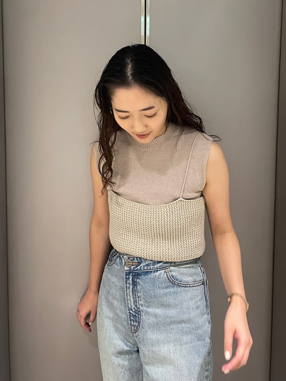 ブルー系のデニムパンツ、ベージュ系のニット/セーター、ブラック系のサンダルを着用したレディースの春コーディネートの6枚目の写真