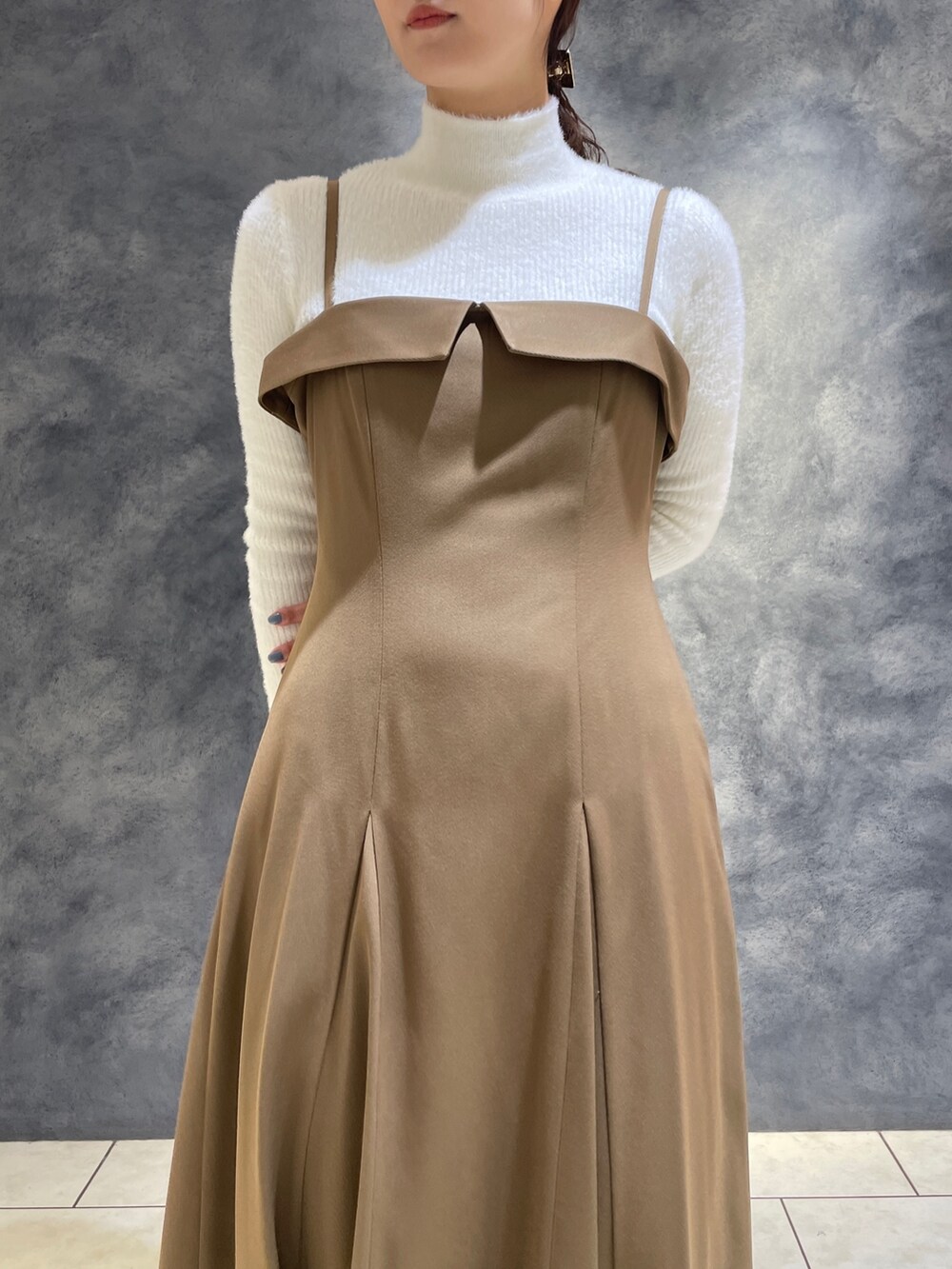 ベージュ系のワンピース、ホワイト系のニット/セーター、ホワイト系のブーツを着用したレディースの冬コーディネートの9枚目の写真