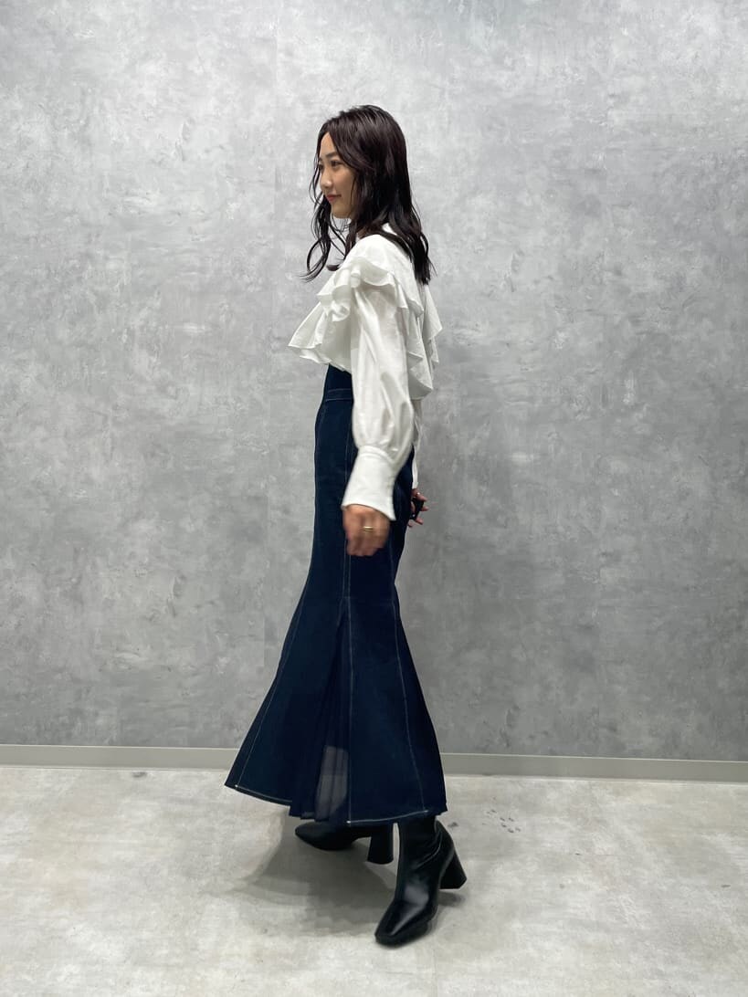 ブラック系のブーツ、ブルー系のスカート、ホワイト系のシャツ/ブラウスを着用したレディースの秋コーディネートの5枚目の写真