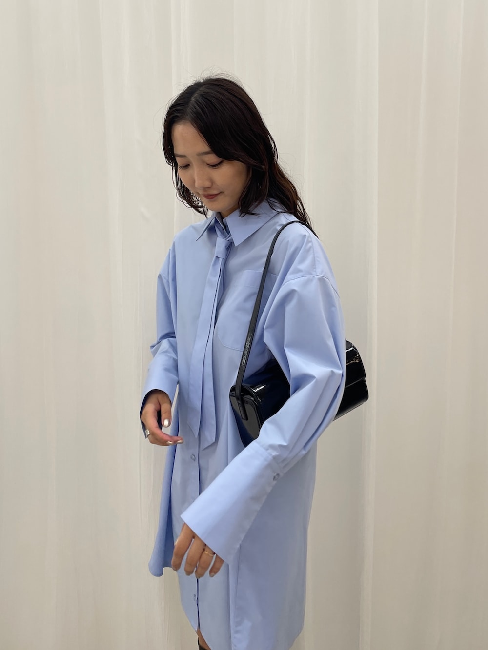 ブルー系のシャツワンピース、ブラック系のショルダーバッグを着用したレディースの秋コーディネートの7枚目の写真