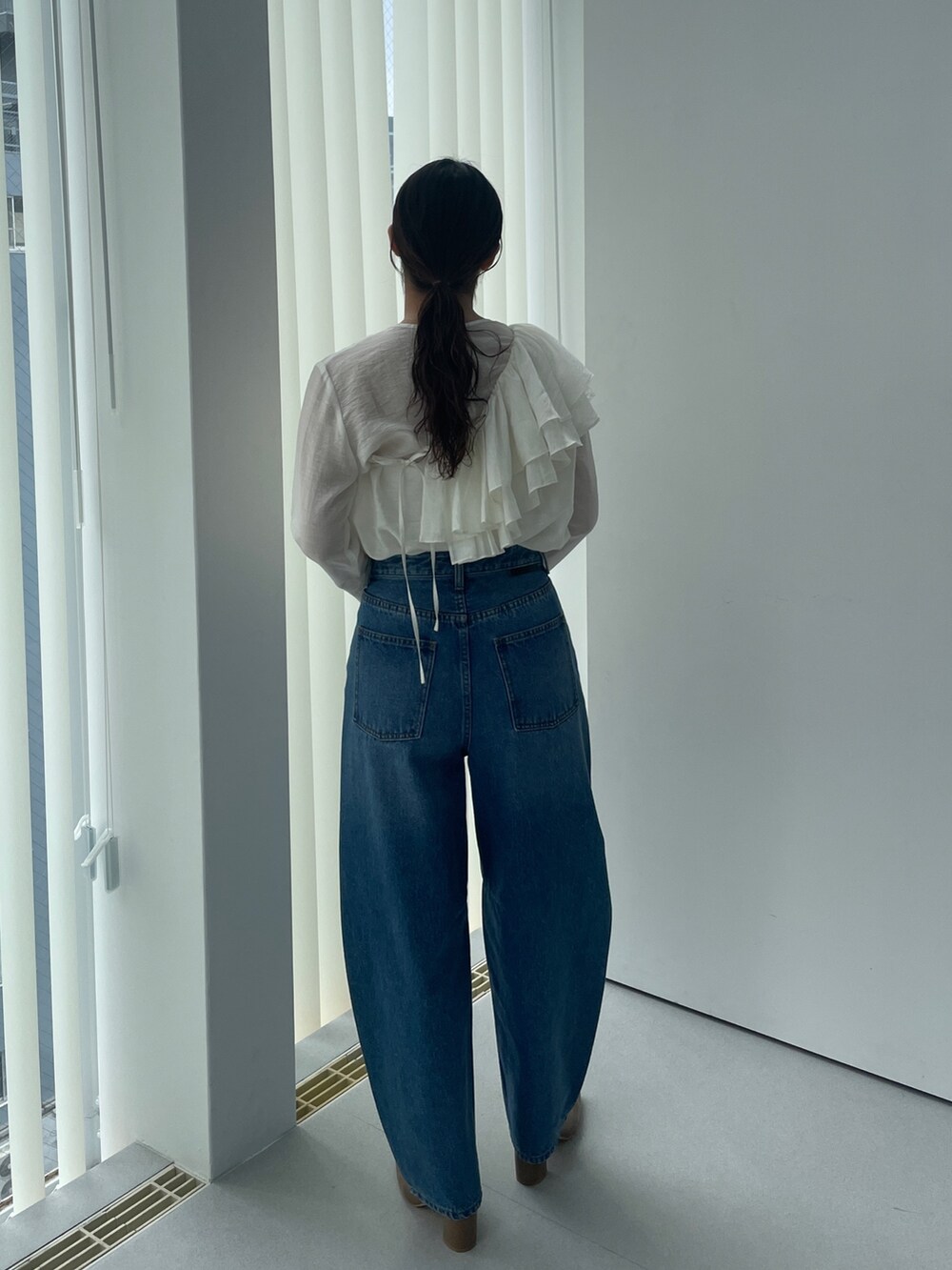 ベージュ系のブーツ、ホワイト系のシャツ/ブラウス、ブルー系のデニムパンツを着用したレディースの夏コーディネートの6枚目の写真