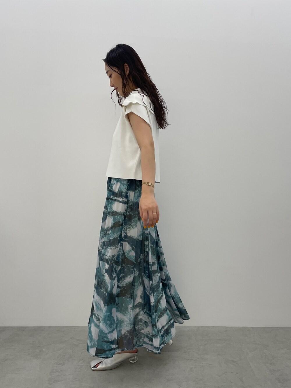 シルバー系のパンプス、ブルー系のスカート、ホワイト系のTシャツ/カットソーを着用したレディースの春コーディネートの7枚目の写真