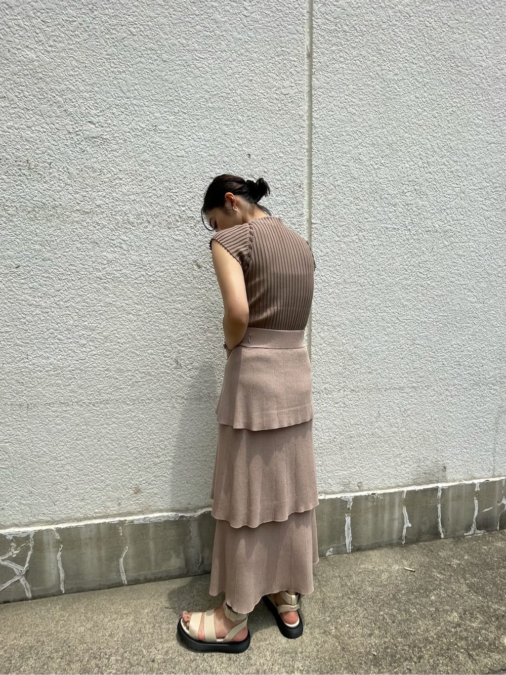 ベージュ系のスカート、ホワイト系のサンダル、ベージュ系のニット/セーターを着用したレディースの夏コーディネートの3枚目の写真