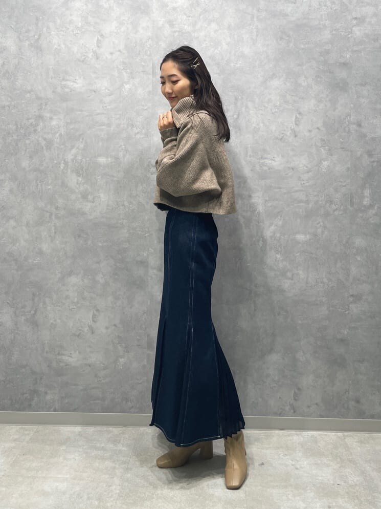 ベージュ系のブーツ、ブルー系のスカート、ベージュ系のカーディガン/ボレロを着用したレディースの秋コーディネートの2枚目の写真