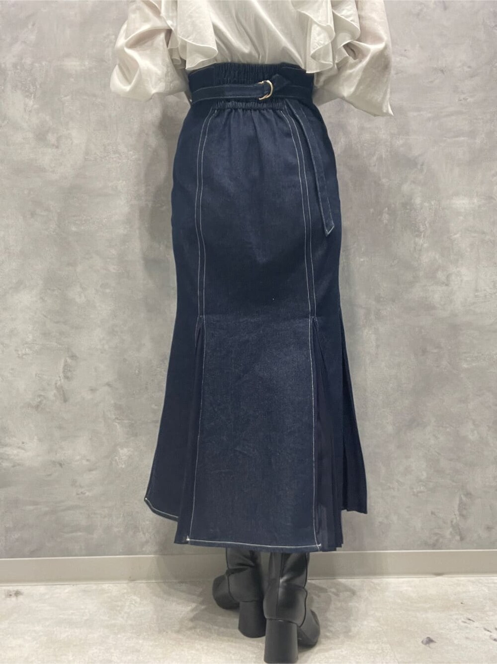 ブラック系のブーツ、ブルー系のスカート、ホワイト系のシャツ/ブラウスを着用したレディースの秋コーディネートの8枚目の写真