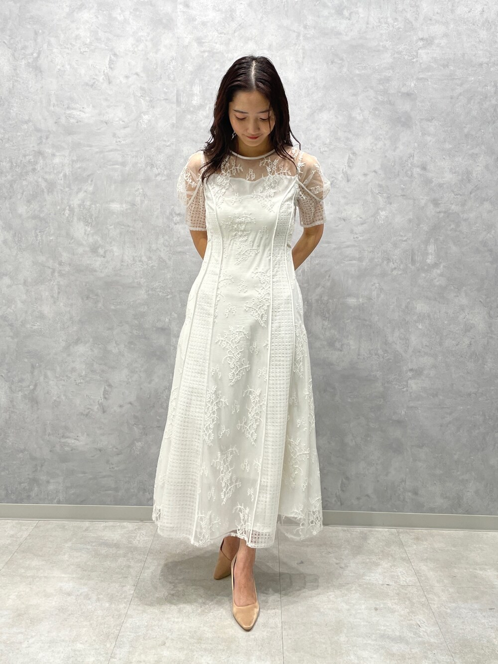 ベージュ系のその他アウター、ゴールド系のパンプス、ホワイト系のドレスを着用したレディースの冬コーディネートの7枚目の写真