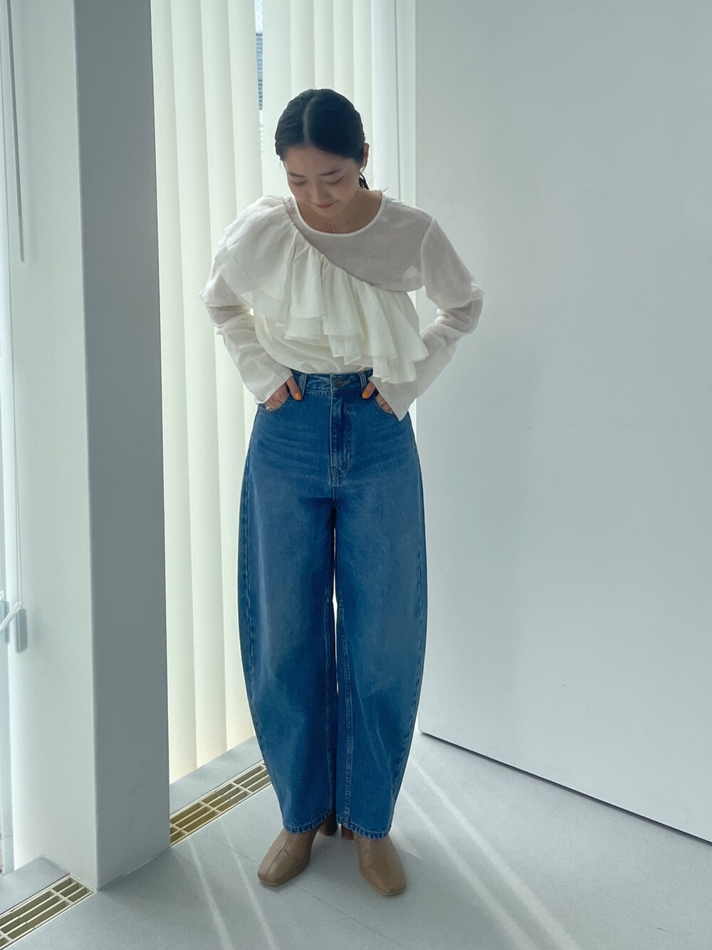 ベージュ系のブーツ、ホワイト系のシャツ/ブラウス、ブルー系のデニムパンツを着用したレディースの夏コーディネートの2枚目の写真