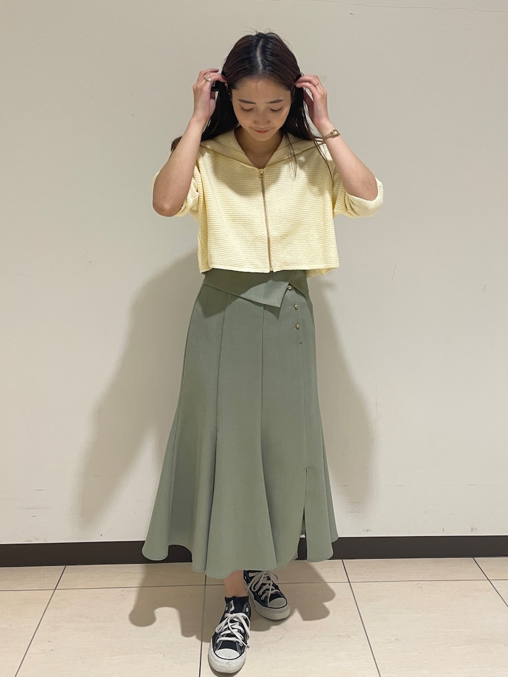 ホワイト系のカーディガン/ボレロ、グリーン系のスカートを着用したレディースの春コーディネートの3枚目の写真