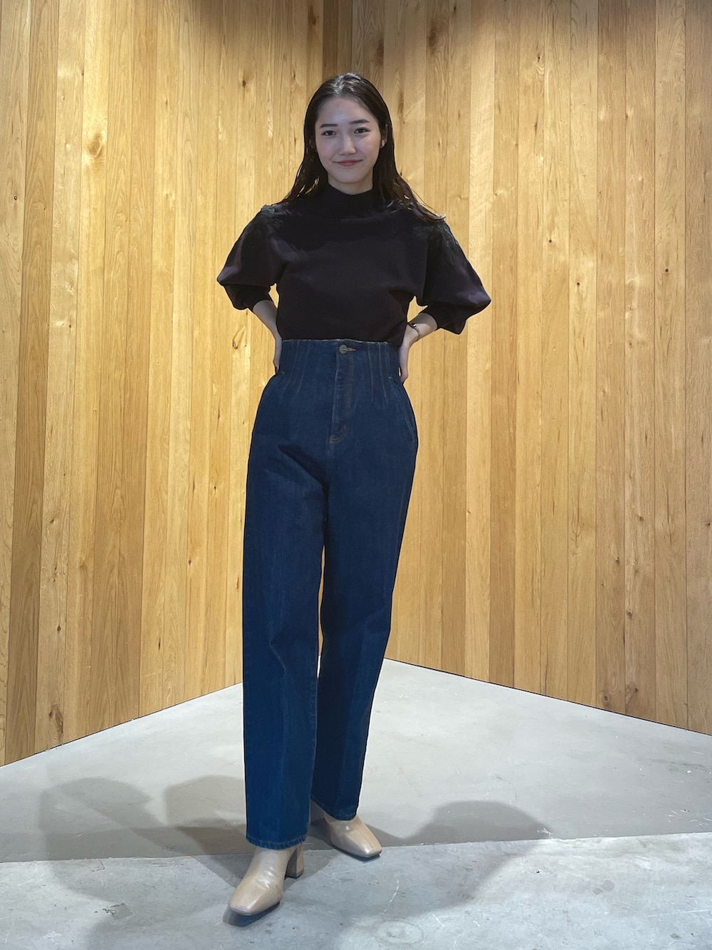 ベージュ系のブーツ、グレー系のニット/セーター、ブルー系のデニムパンツを着用したレディースの秋コーディネートの4枚目の写真