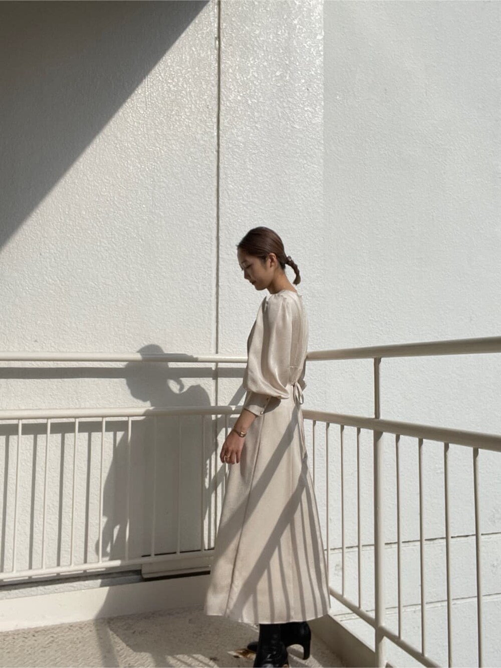 ブラック系のその他シューズ、ブラック系のその他アウター、ホワイト系のワンピースを着用したレディースの冬コーディネートの3枚目の写真