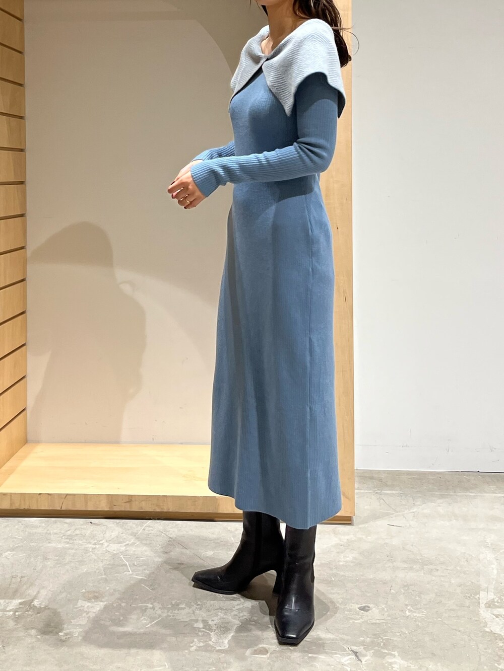 ブラック系のブーツ、ブルー系のワンピースを着用したレディースの冬コーディネートの2枚目の写真