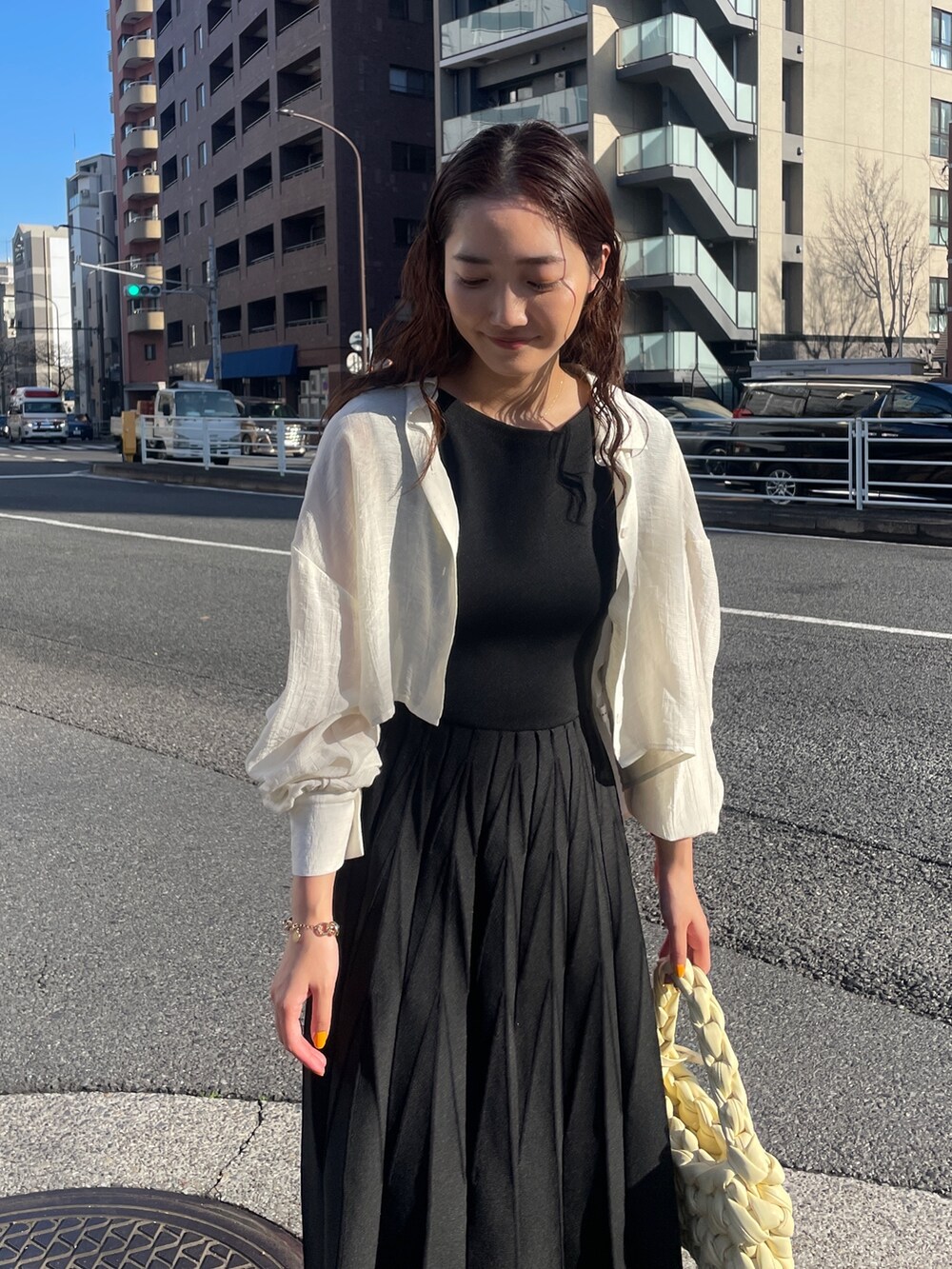 ブラック系のワンピース、ベージュ系のハンドバッグ、ブラック系のサンダルを着用したレディースの春コーディネートの7枚目の写真