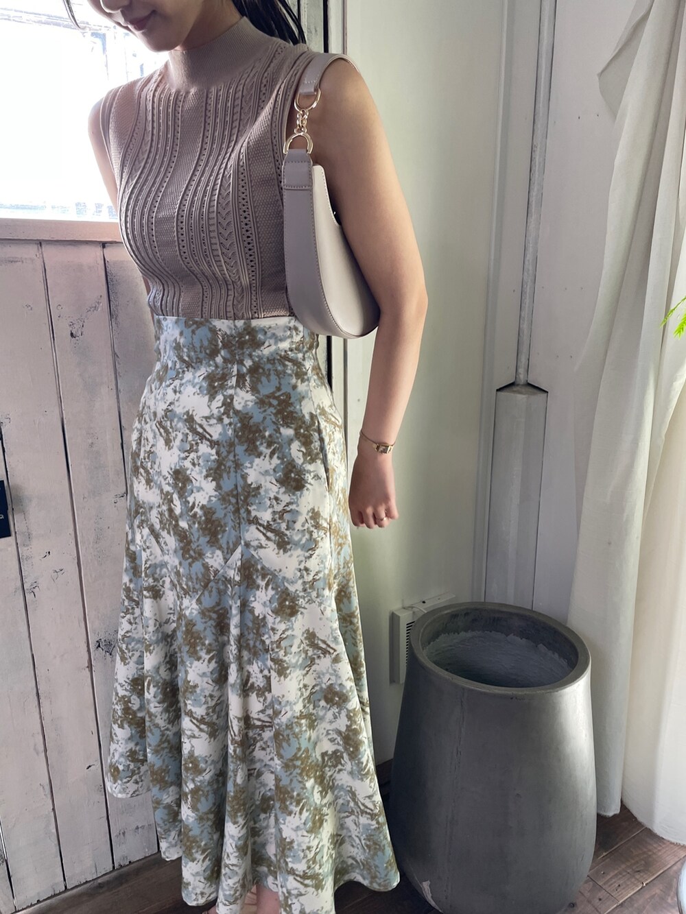 ベージュ系のサンダル、グリーン系のスカート、ベージュ系のニット/セーターを着用したレディースの春コーディネートの6枚目の写真