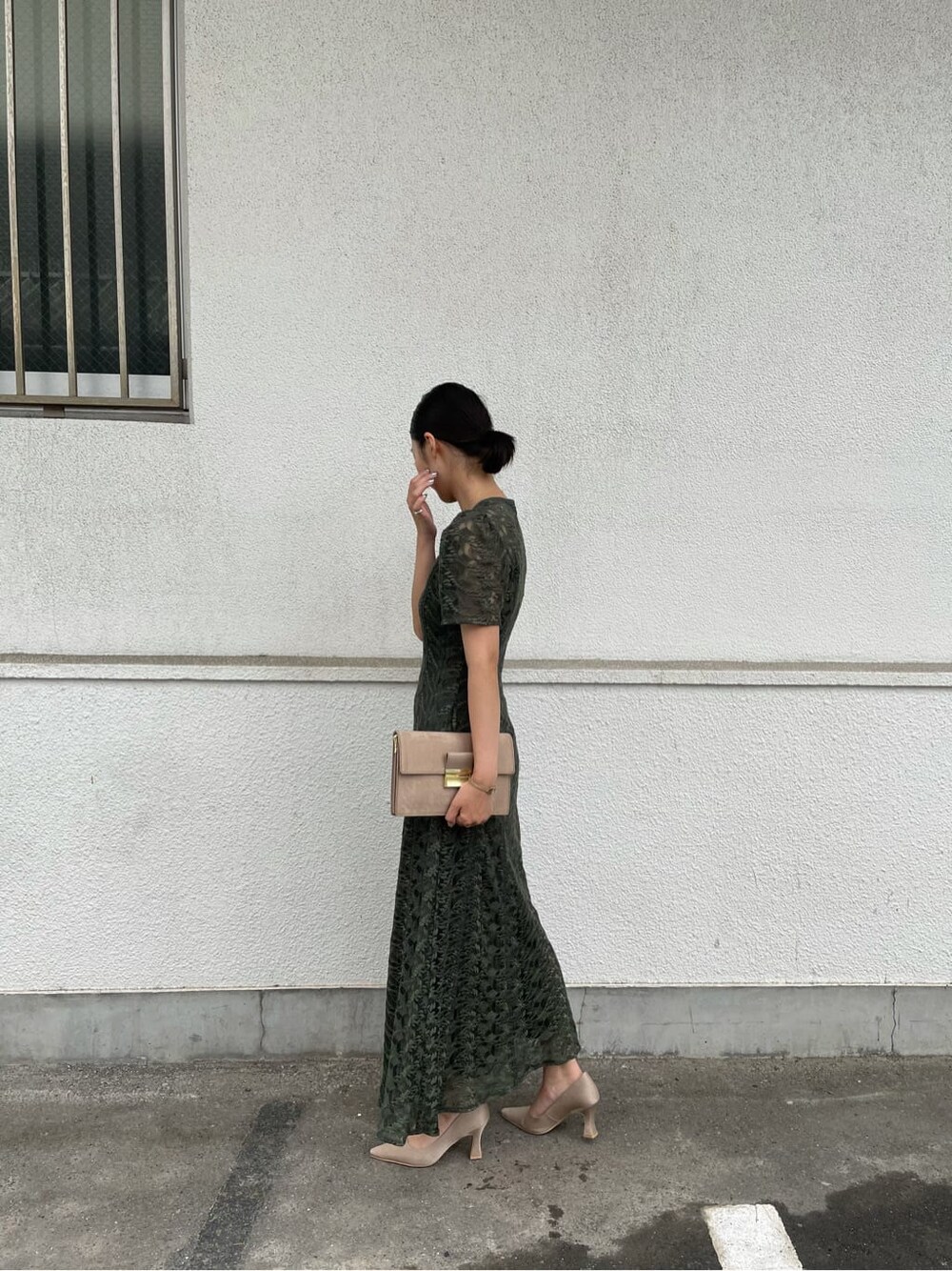 グリーン系のドレス、ベージュ系のパンプス、ブラウン系のクラッチバッグを着用したレディースの夏コーディネートの3枚目の写真