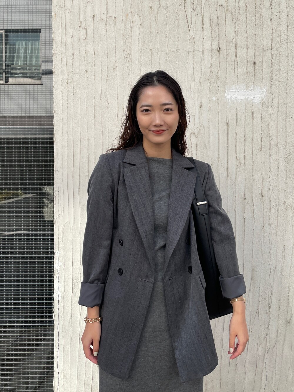 ホワイト系のスニーカー、グレー系のワンピース、グレー系のテーラードジャケットを着用したレディースの冬コーディネートの6枚目の写真