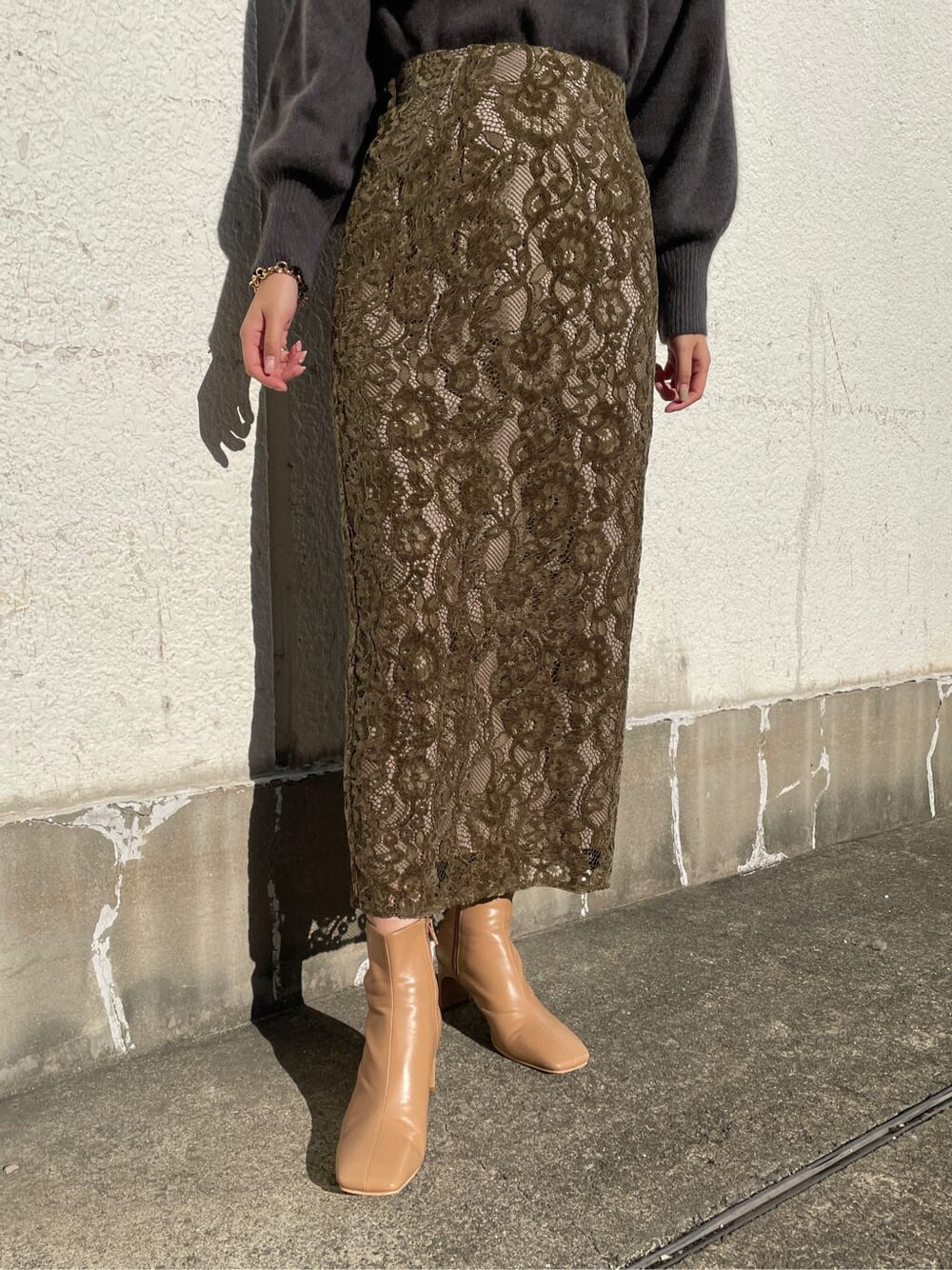 ベージュ系のその他シューズ、ベージュ系のスカート、グレー系のニット/セーターを着用したレディースの冬コーディネートの6枚目の写真