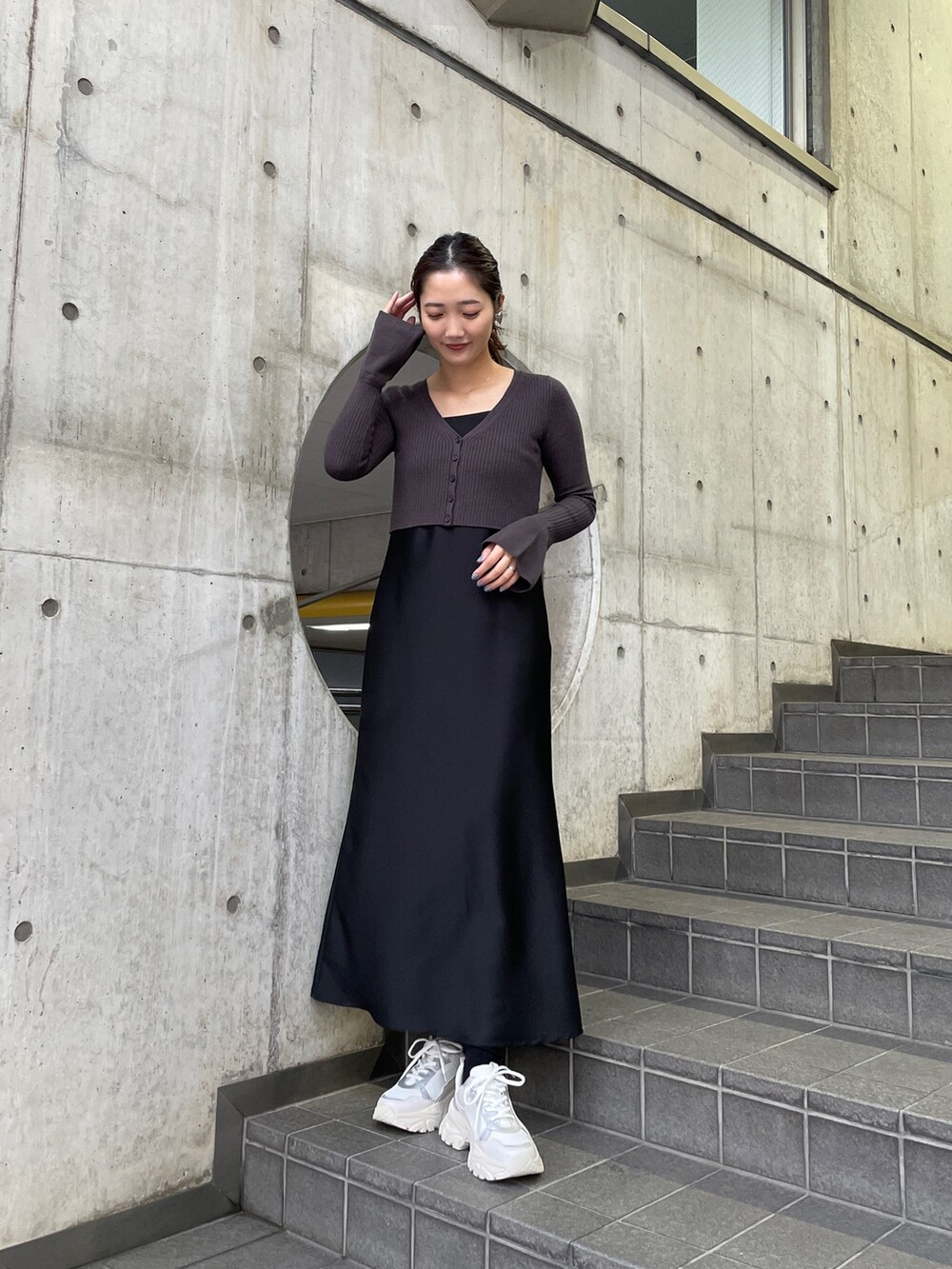 ホワイト系のスニーカー、ブラック系のワンピースを着用したレディースの冬コーディネートの3枚目の写真