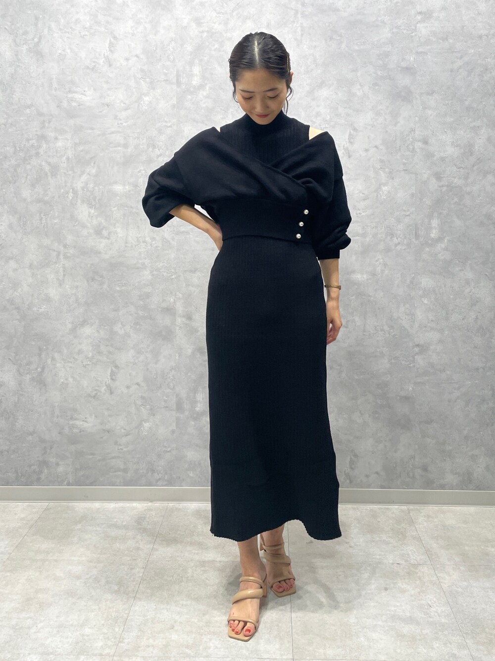 ベージュ系のサンダル、ブラック系のワンピースを着用したレディースの冬コーディネートの2枚目の写真