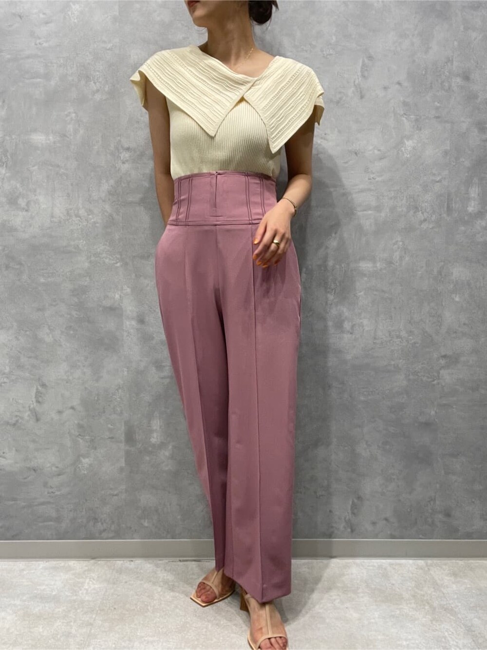 ピンク系のその他パンツ、ベージュ系のサンダル、ホワイト系のニット/セーターを着用したレディースの春コーディネートの2枚目の写真