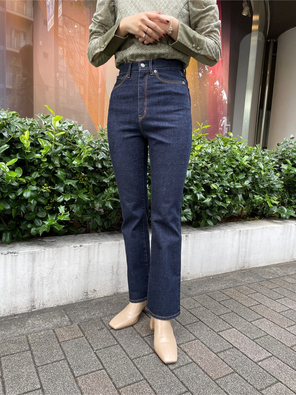 ベージュ系のシャツ/ブラウス、ブラック系のブルゾン、ブルー系のデニムパンツを着用したレディースの秋コーディネートの9枚目の写真