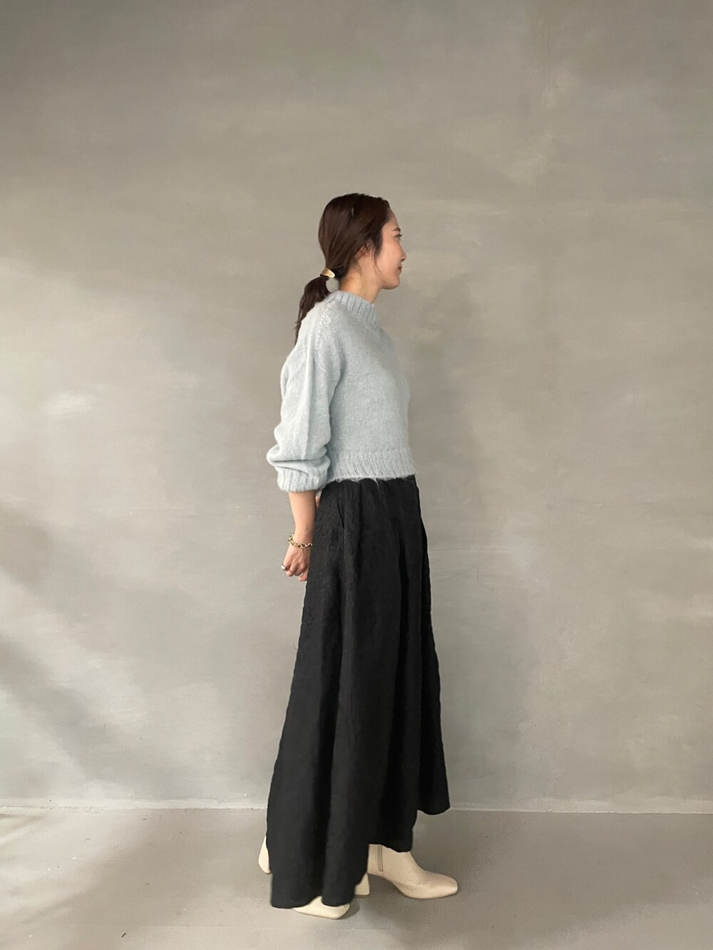 ホワイト系のブーツ、ブラック系のスカート、グリーン系のニット/セーターを着用したレディースの夏コーディネートの4枚目の写真