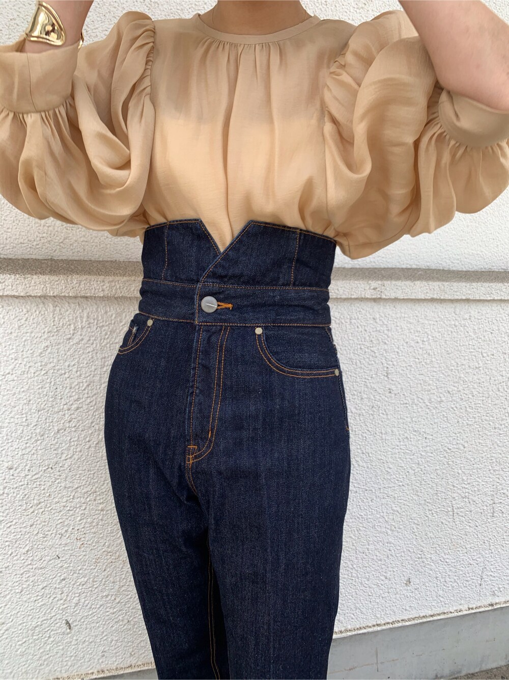 ベージュ系のシャツ/ブラウス、ブルー系のデニムパンツ、ゴールド系のバングル/リストバンドを着用したレディースの春コーディネートの2枚目の写真