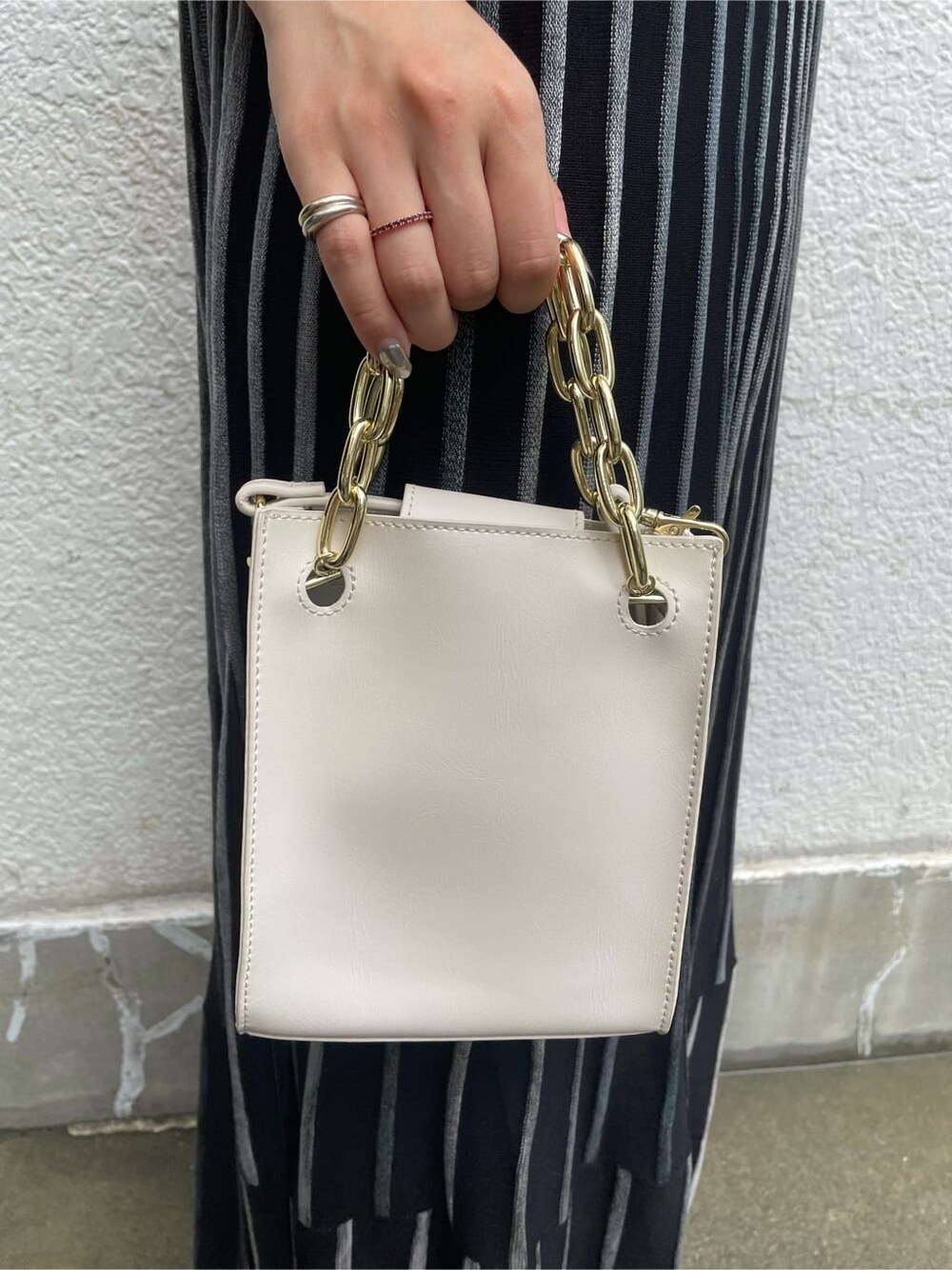 ブラック系のワンピース、ホワイト系のショルダーバッグを着用したレディースの夏コーディネートの6枚目の写真