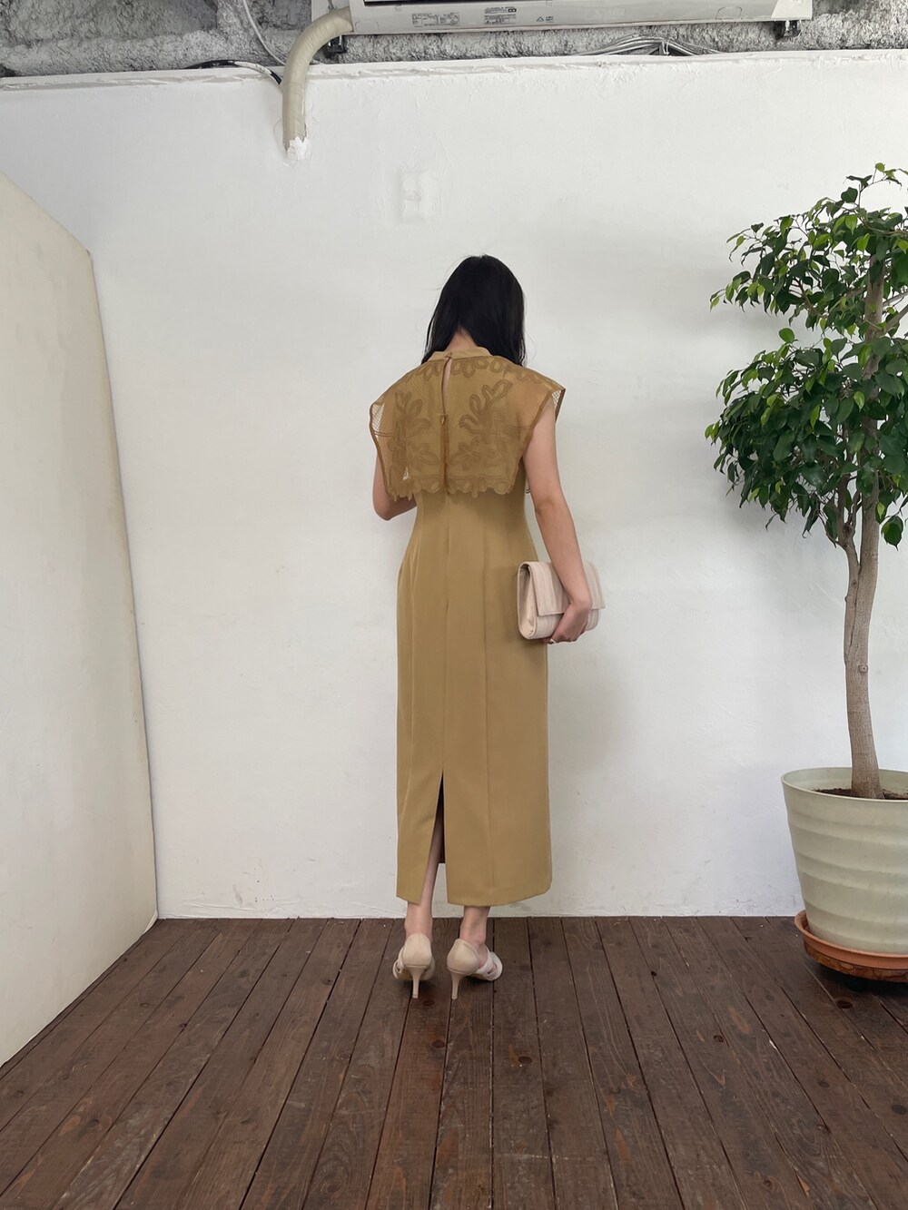 ベージュ系のドレス、ベージュ系のハンドバッグ、ベージュ系のパンプスを着用したレディースの春コーディネートの6枚目の写真