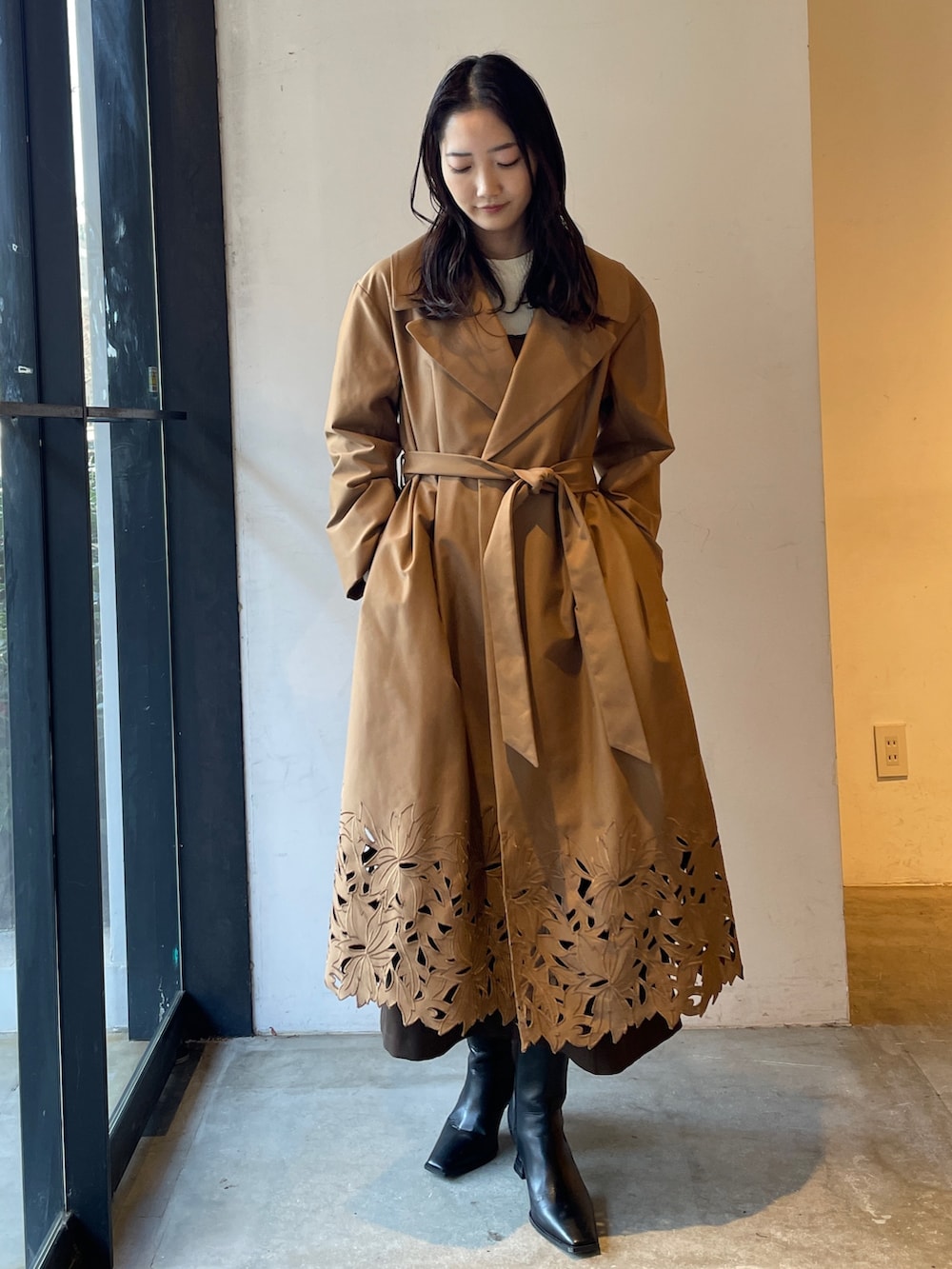 ブラック系のブーツ、ホワイト系のニット/セーター、ブラウン系のジャンパースカートを着用したレディースの冬コーディネートの9枚目の写真