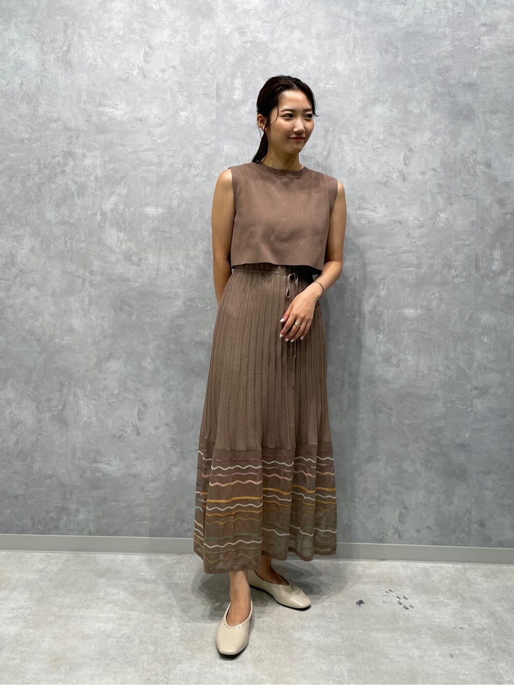 ブラウン系のワンピース、ホワイト系のパンプスを着用したレディースの夏コーディネートの2枚目の写真