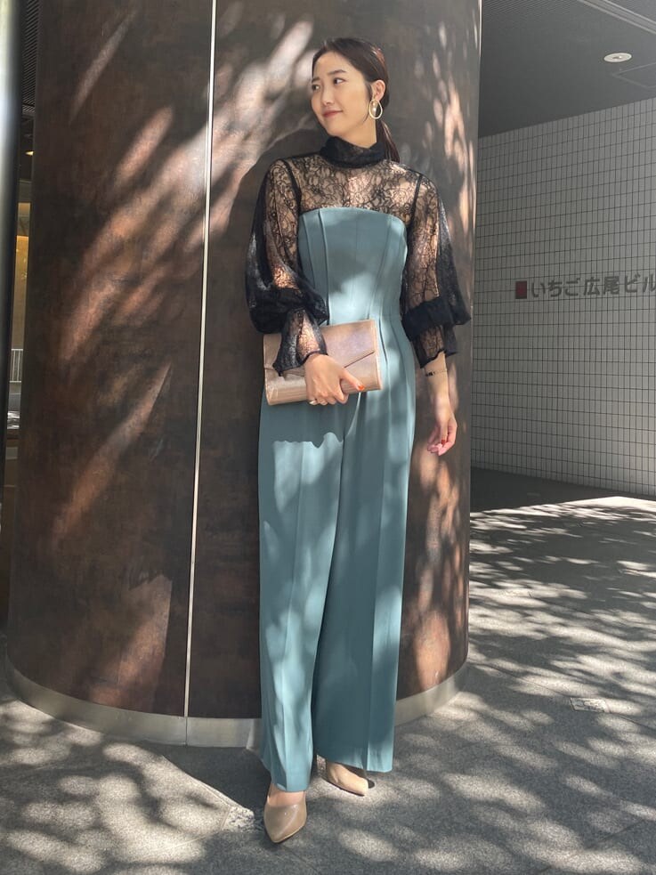 ゴールド系のクラッチバッグ、ゴールド系のパンプス、ブラック系のシャツ/ブラウスを着用したレディースの秋コーディネートの4枚目の写真