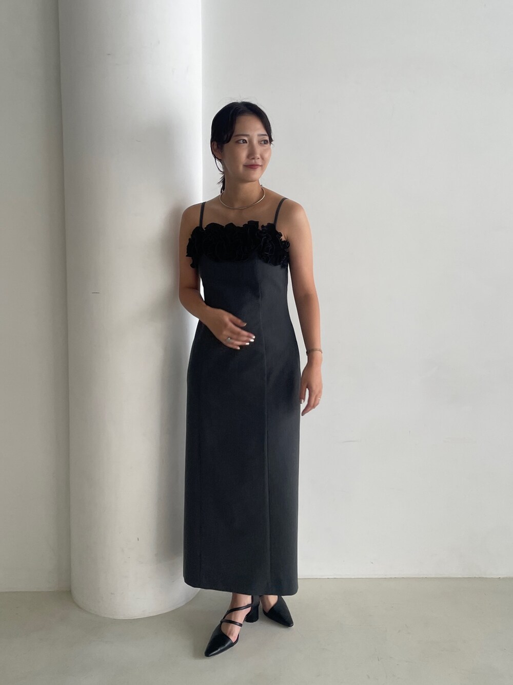 グレー系のドレス、ブラック系のパンプス、グレー系のチェスターコートを着用したレディースの秋コーディネートの7枚目の写真