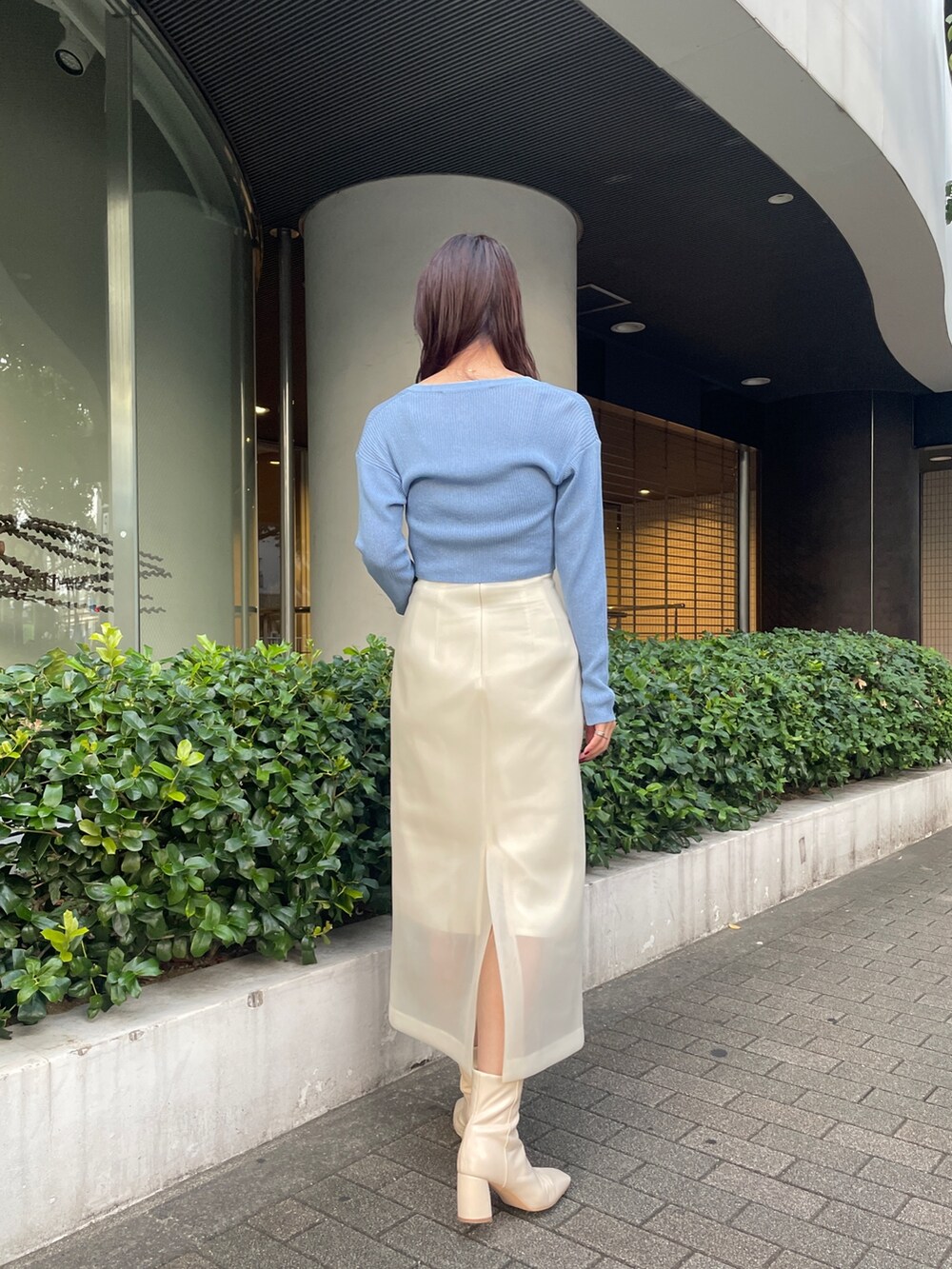 ホワイト系のブーツ、ホワイト系のスカート、ブルー系のカーディガン/ボレロを着用したレディースの秋コーディネートの5枚目の写真