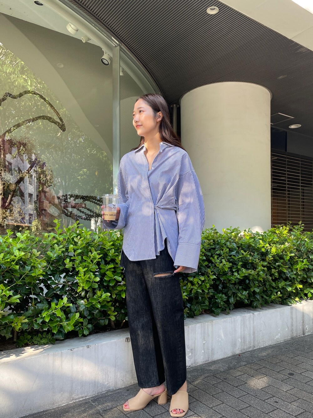 ブラック系のデニムパンツ、ベージュ系のサンダル、ブラック系のシャツ/ブラウスを着用したレディースの夏コーディネートの4枚目の写真