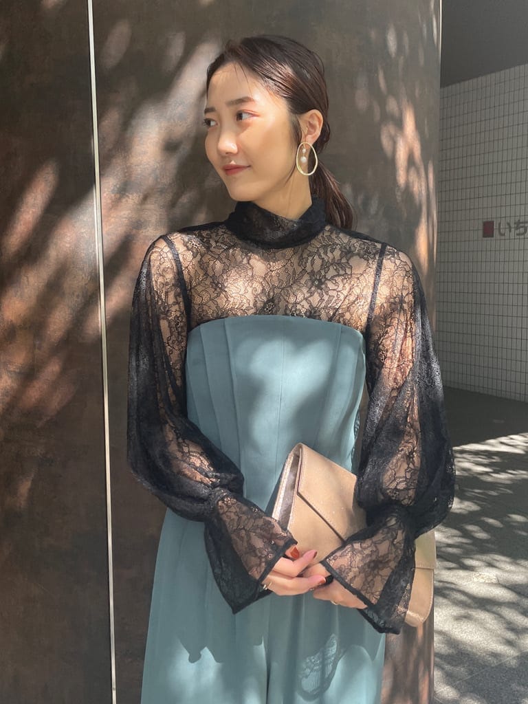 ゴールド系のクラッチバッグ、ゴールド系のパンプス、ブラック系のシャツ/ブラウスを着用したレディースの秋コーディネートの7枚目の写真