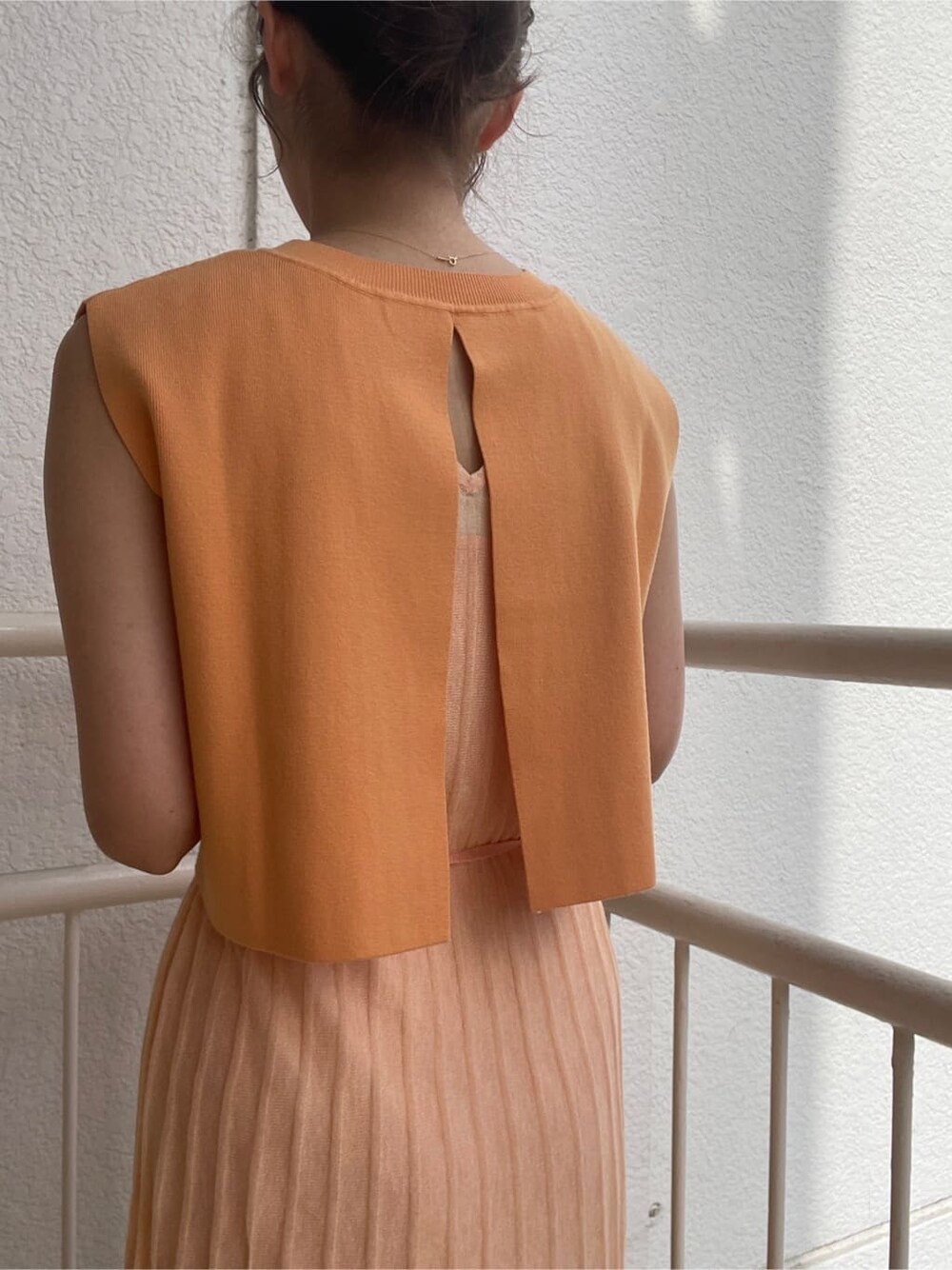 ベージュ系のブーツ、ベージュ系のテーラードジャケット、オレンジ系のワンピースを着用したレディースの春コーディネートの9枚目の写真