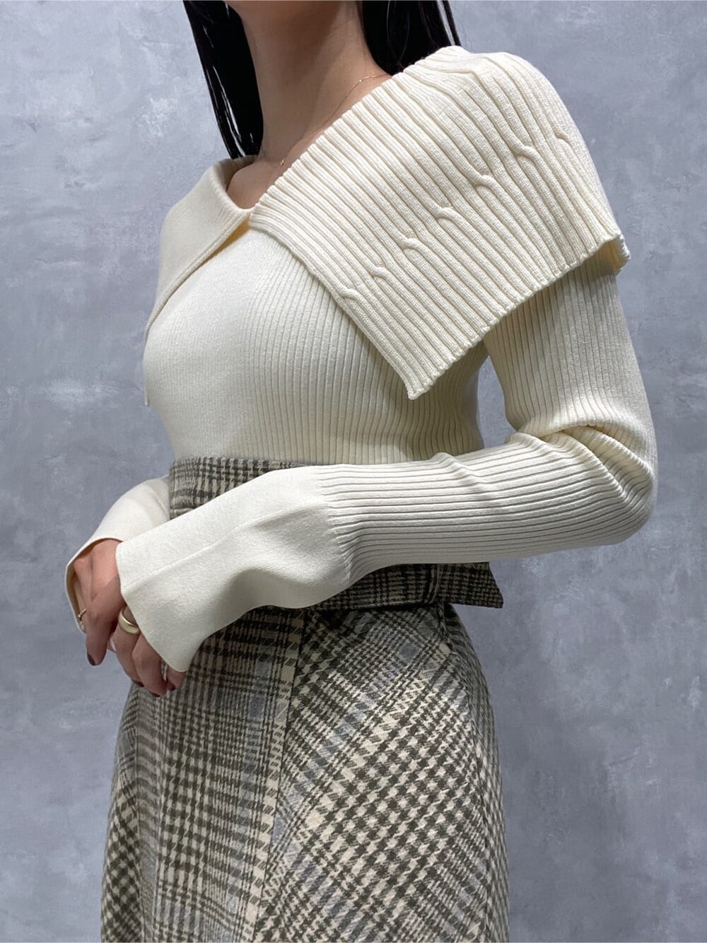 ブラック系のブーツ、ベージュ系のスカート、ホワイト系のニット/セーターを着用したレディースの秋コーディネートの6枚目の写真