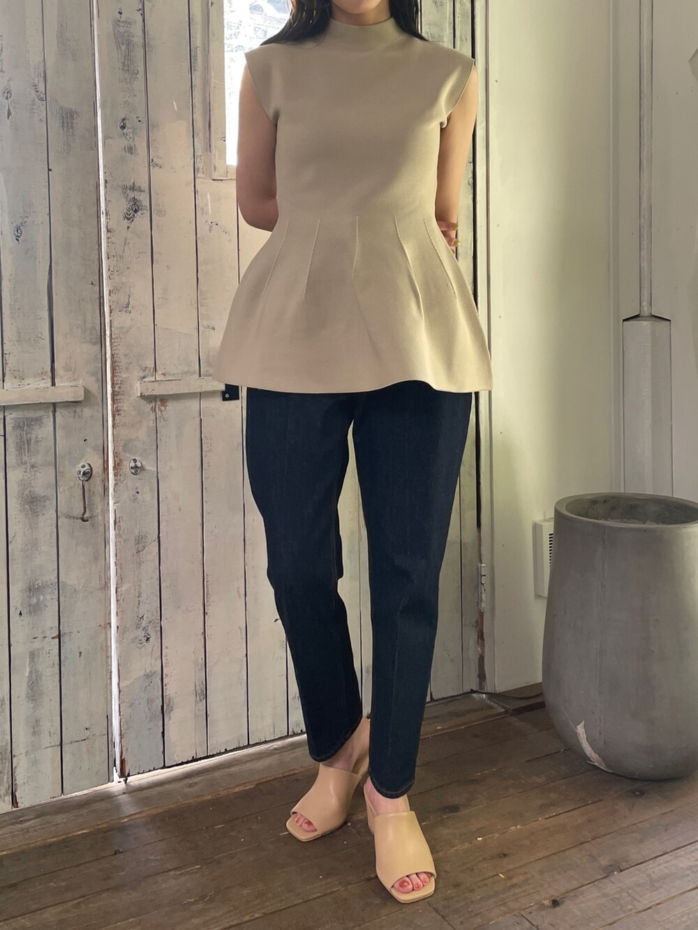 ベージュ系のニット/セーター、ブルー系のデニムパンツ、ベージュ系のサンダルを着用したレディースの春コーディネートの2枚目の写真