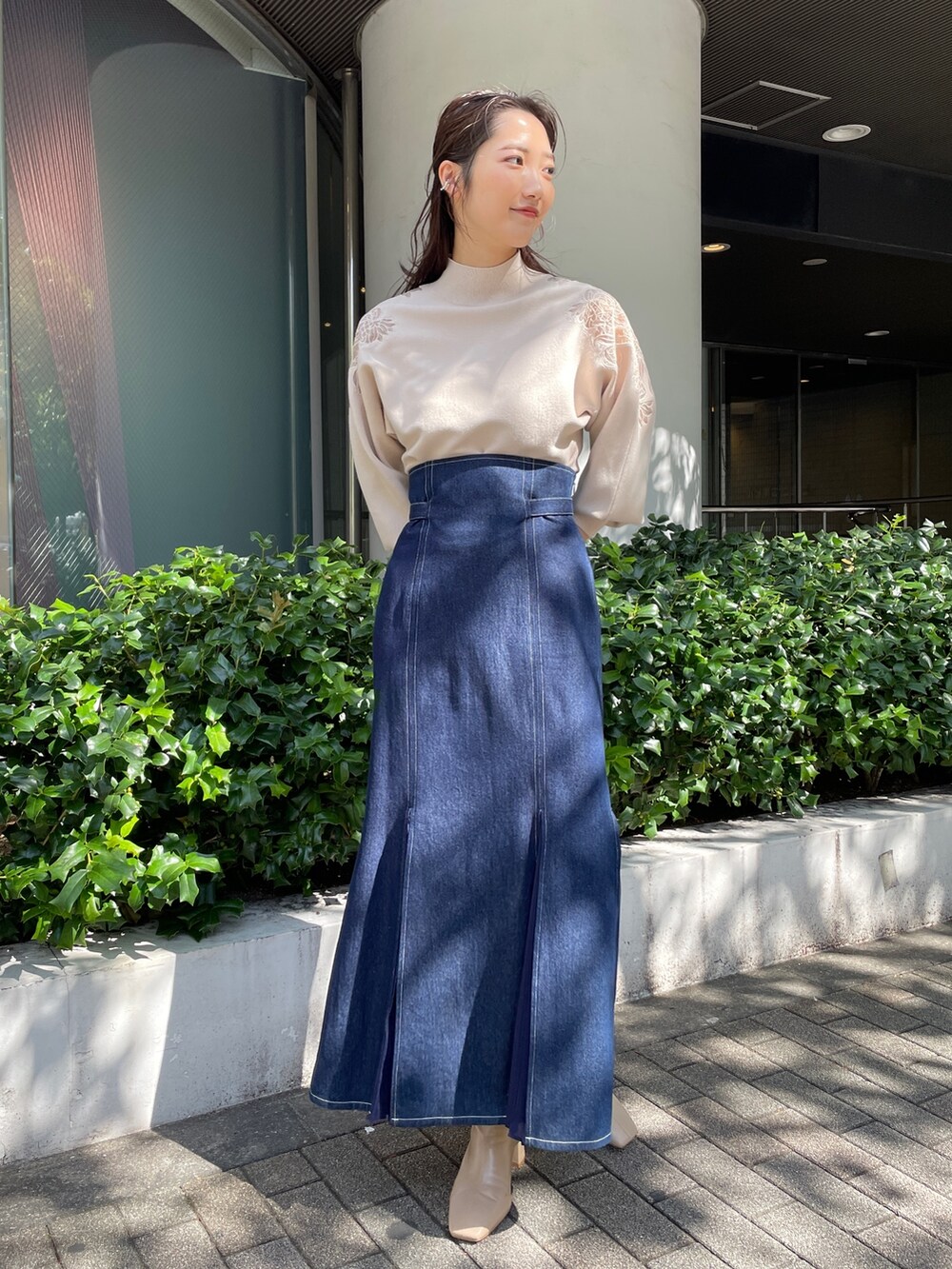 ベージュ系のブーツ、ブルー系のスカート、ホワイト系のニット/セーターを着用したレディースの秋コーディネートの6枚目の写真