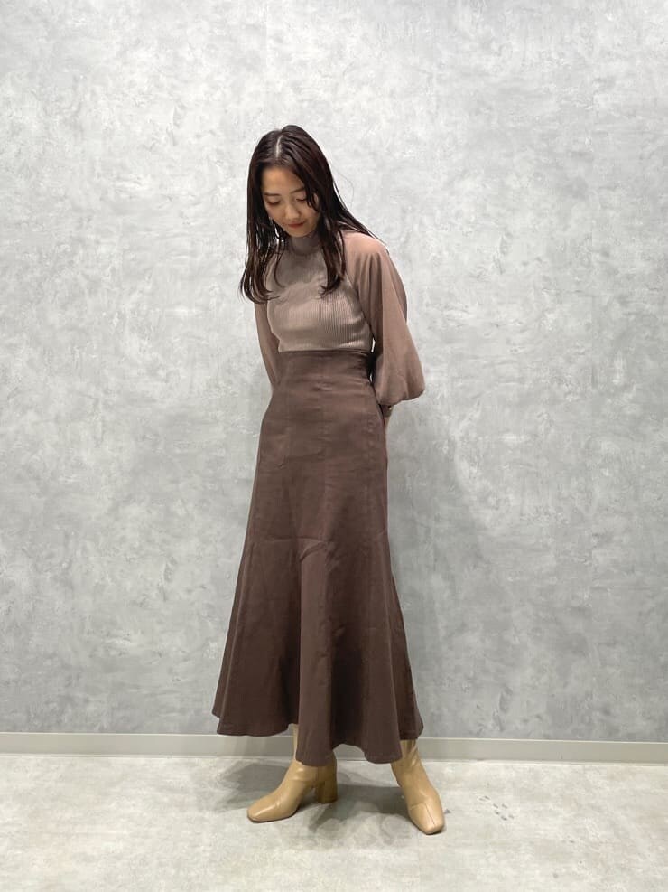 ベージュ系のブーツ、ブラウン系のスカート、ベージュ系のニット/セーターを着用したレディースの秋コーディネートの4枚目の写真