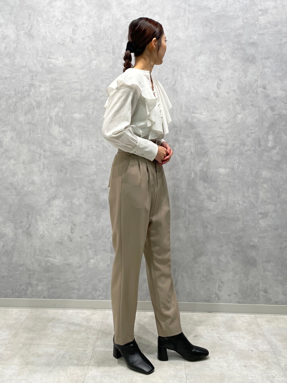 ホワイト系のカーディガン/ボレロ、ブラック系のブーツ、ホワイト系のシャツ/ブラウスを着用したレディースの冬コーディネートの7枚目の写真