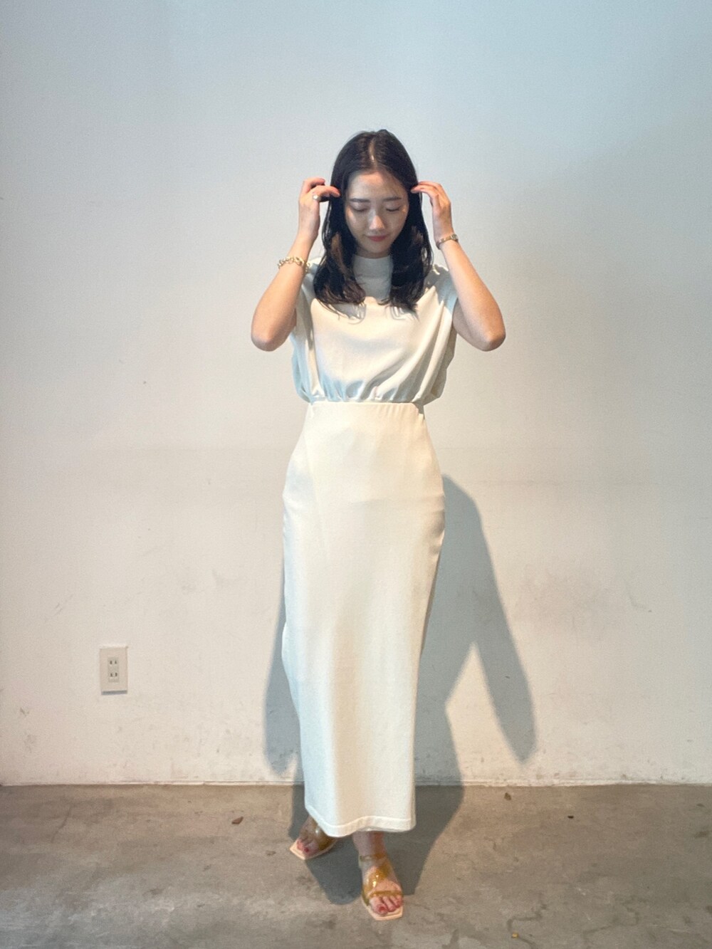 ホワイト系のスカート、ホワイト系のニット/セーター、イエロー系のサンダルを着用したレディースの夏コーディネートの3枚目の写真