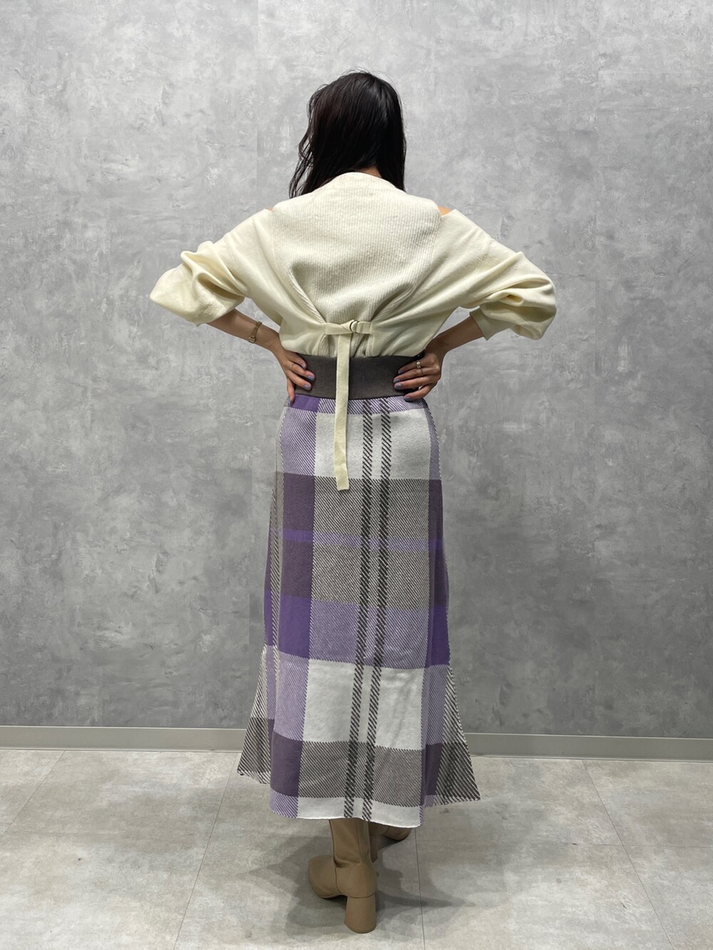 ベージュ系のブーツ、ホワイト系のニット/セーター、パープル系のスカートを着用したレディースの冬コーディネートの6枚目の写真