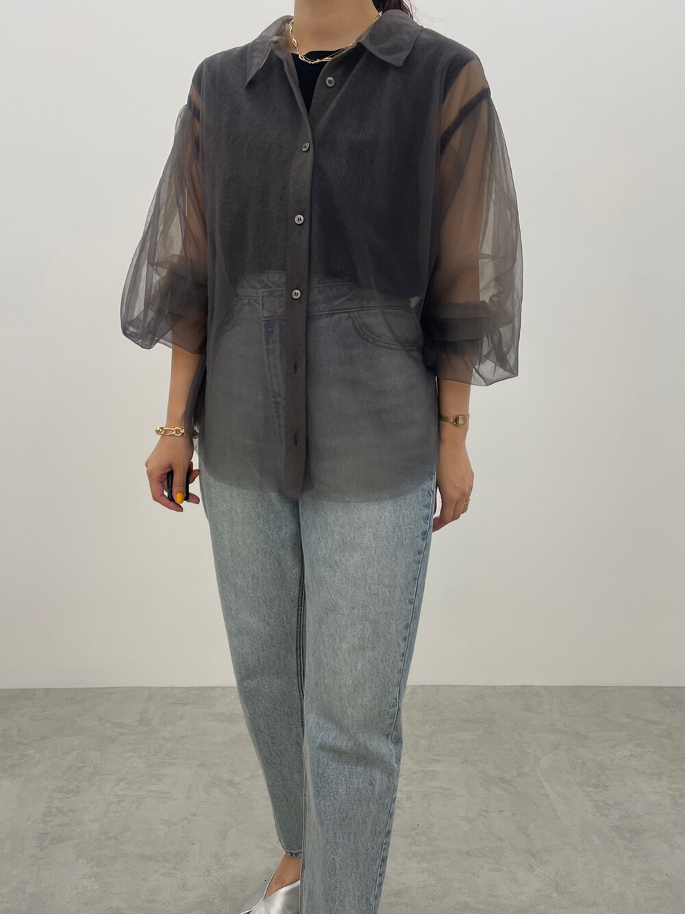 ブルー系のデニムパンツ、シルバー系のパンプス、ブラック系のニット/セーターを着用したレディースの夏コーディネートの6枚目の写真