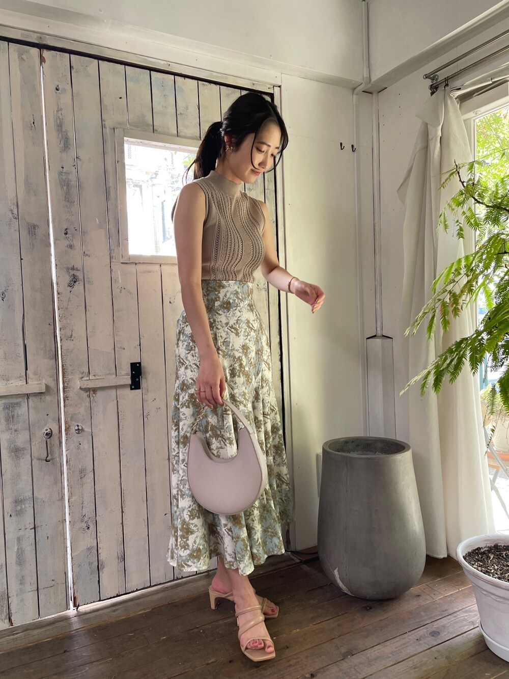 ベージュ系のサンダル、グリーン系のスカート、ベージュ系のニット/セーターを着用したレディースの春コーディネートの2枚目の写真