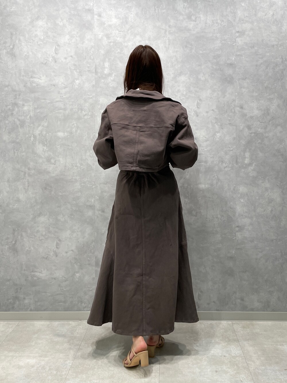 ベージュ系のサンダル、グレー系のスカート、グレー系のテーラードジャケットを着用したレディースの春コーディネートの2枚目の写真