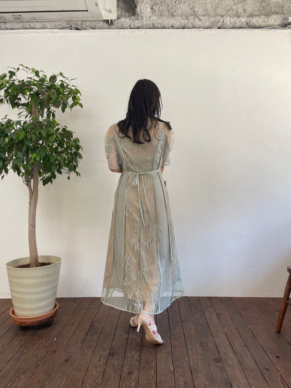 グリーン系のドレス、ベージュ系のハンドバッグ、ベージュ系のパンプスを着用したレディースの春コーディネートの2枚目の写真